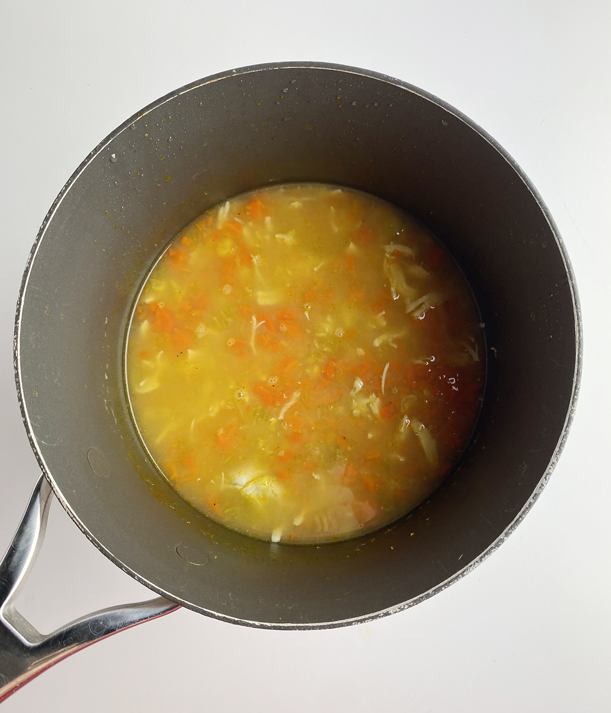 Chicken and vegetable soup in a pot.