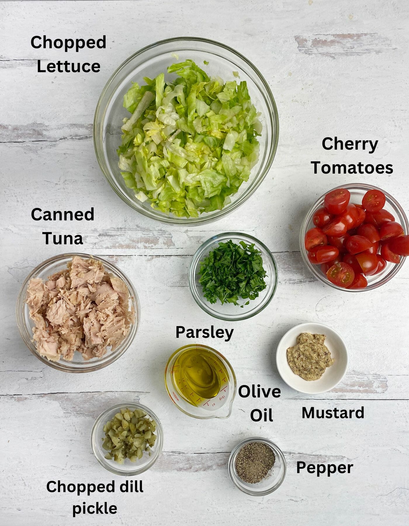 Mustard tuna salad ingredients on a wooden counter.