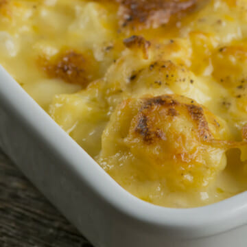 Cheesy cauliflower casserole on a wooden counter.