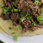 Slow Cooker Mississippi Pot Roast on a plate with grits.