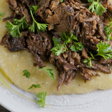Slow Cooker Mississippi Pot Roast on a plate with grits.