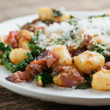 Gnocchi with Bacon and Spinach on a white plate.