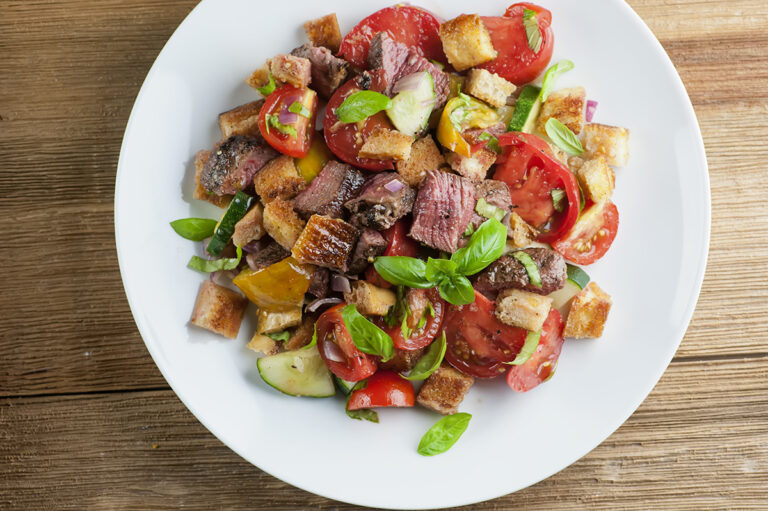 Steak panzanella salad on a plate.