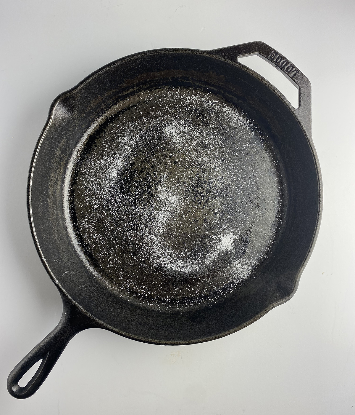 Cast iron skillet with salt scatter in it.