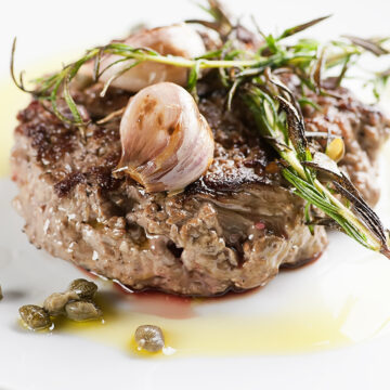 Seared steak tartare with garlic on a plate.