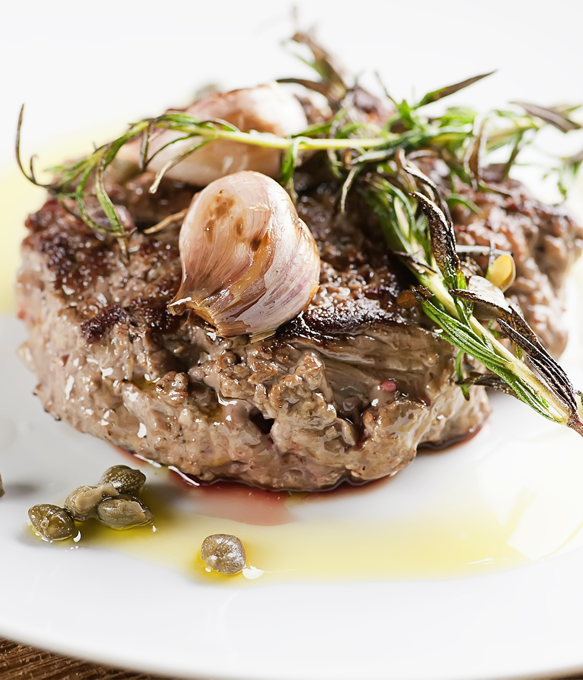 Seared steak tartare with garlic on a plate.