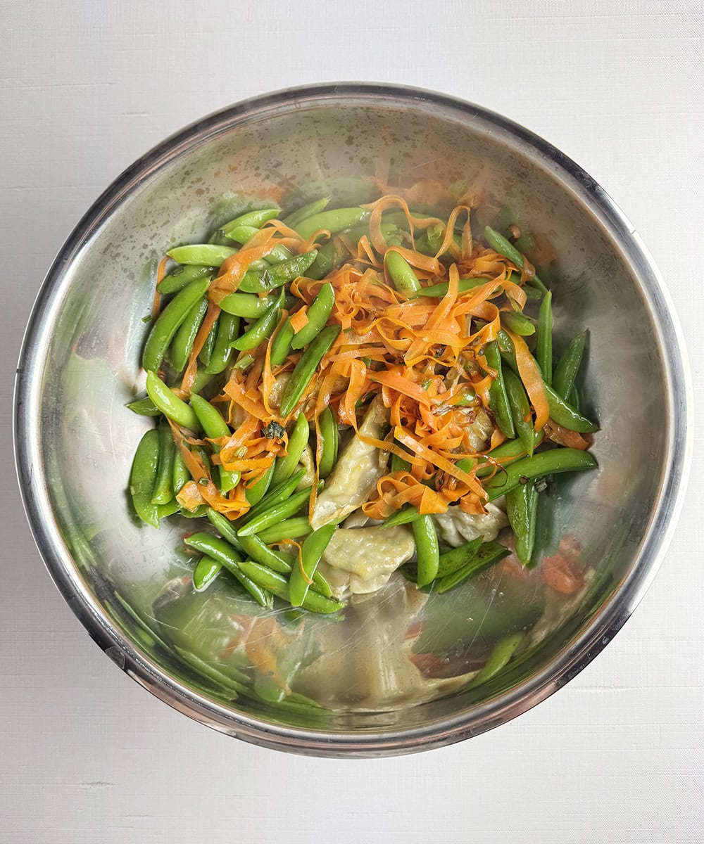 Shrimp dumplings and veggies in a bowl.