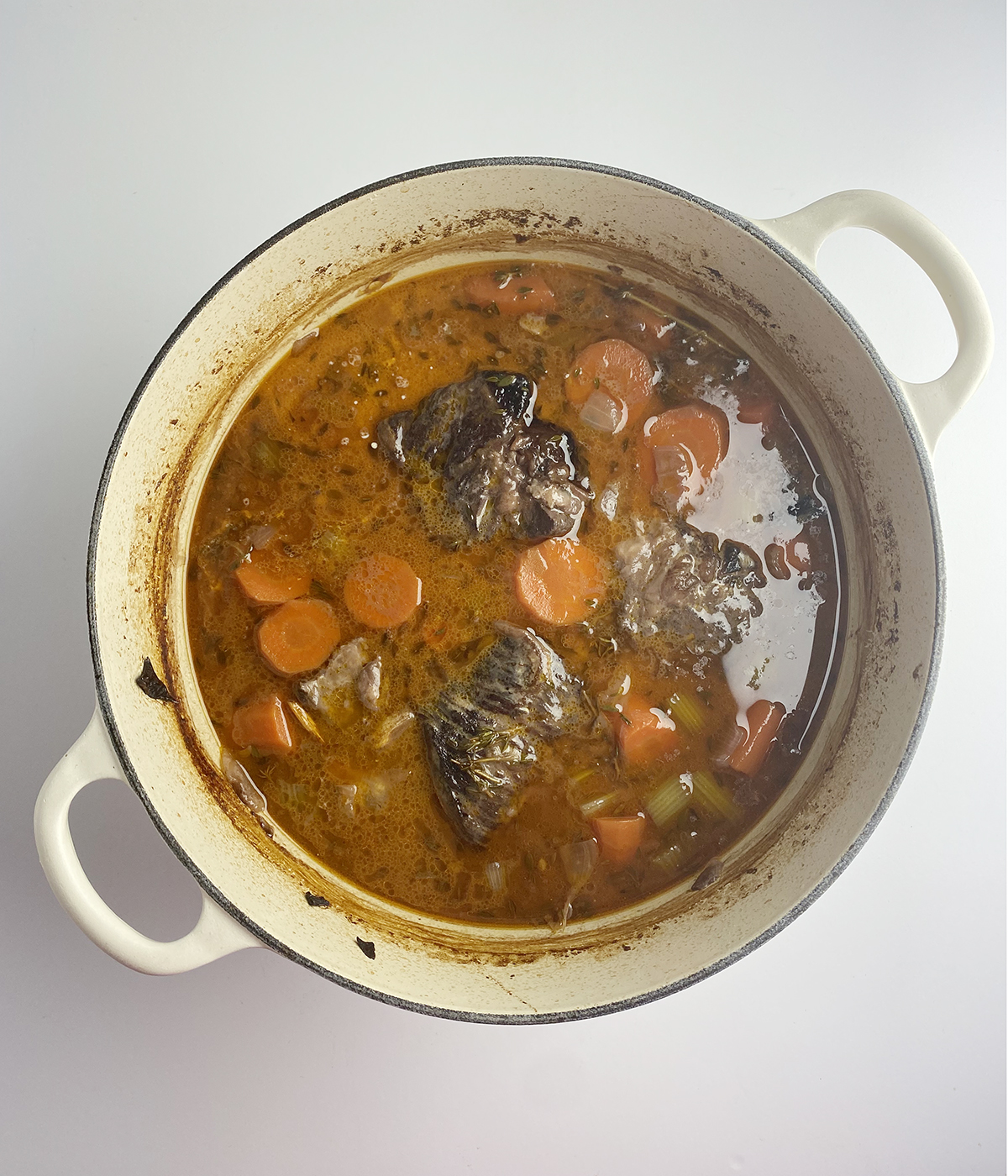 Cooked red wine short ribs in a Dutch oven.