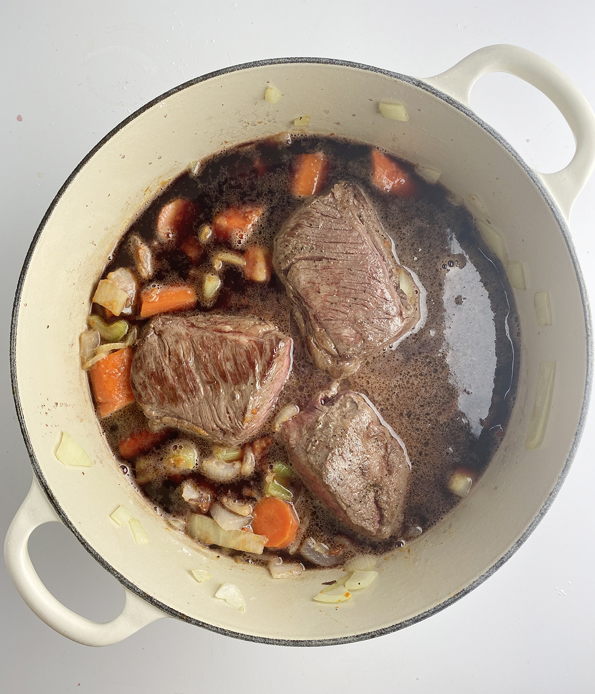 Seared short ribs with wine and veggies in a Dutch Oven.
