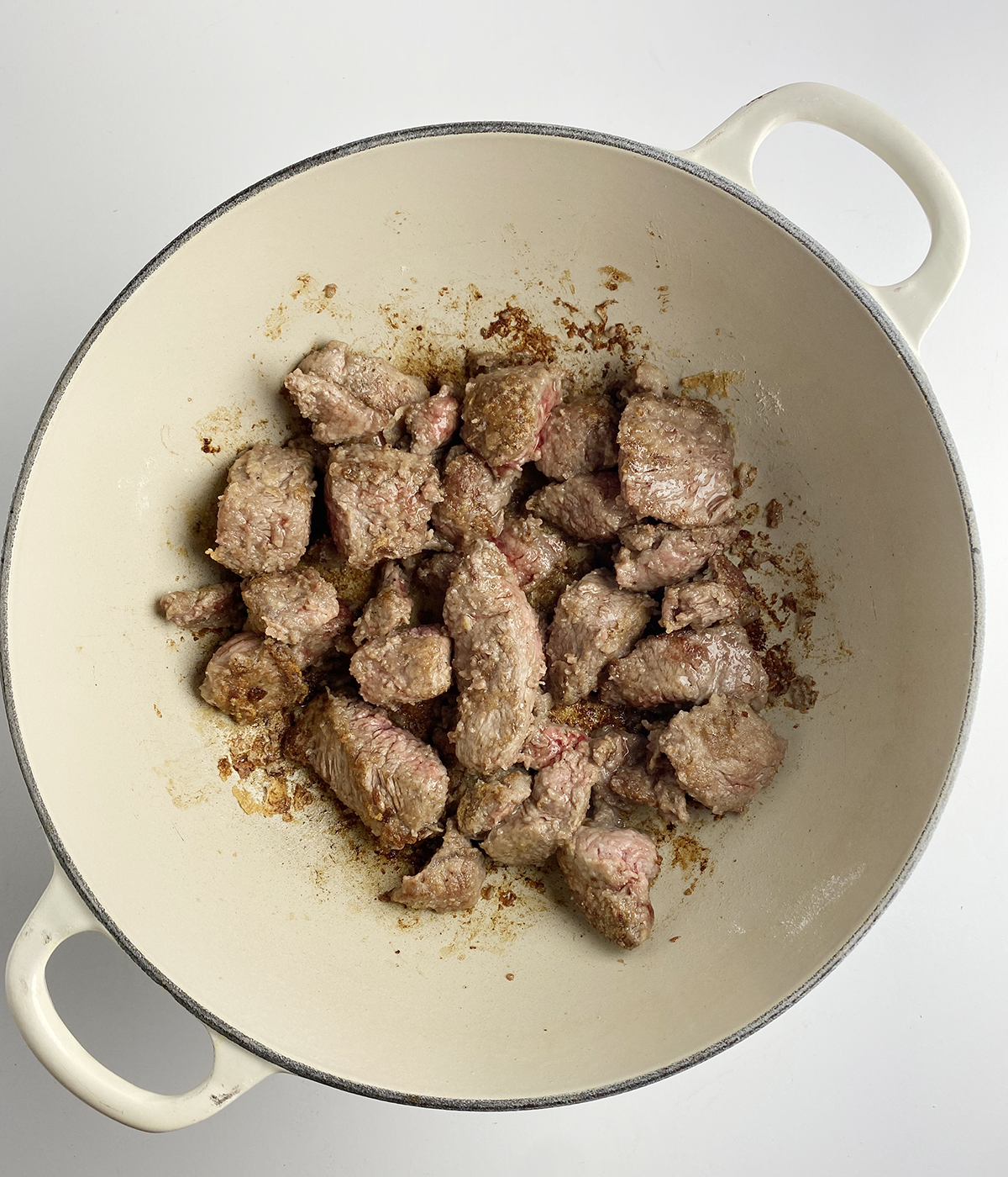 Seared stew beef in a Dutch oven.