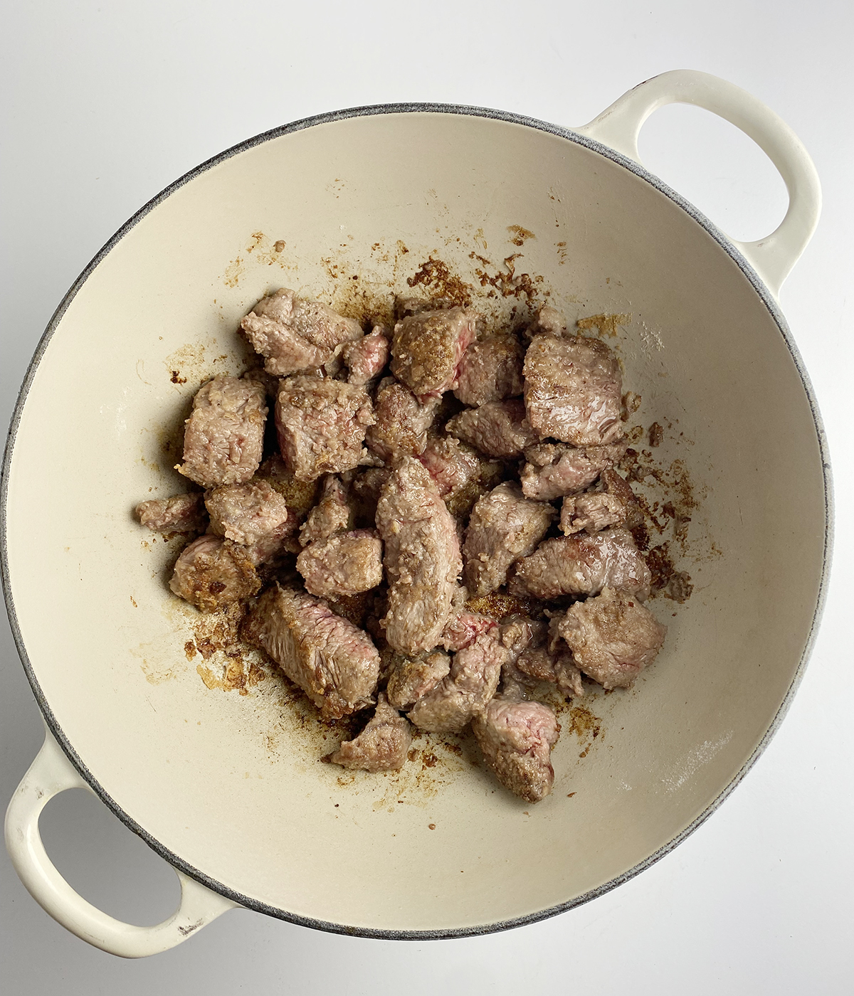 Seared stew beef in a Dutch oven.