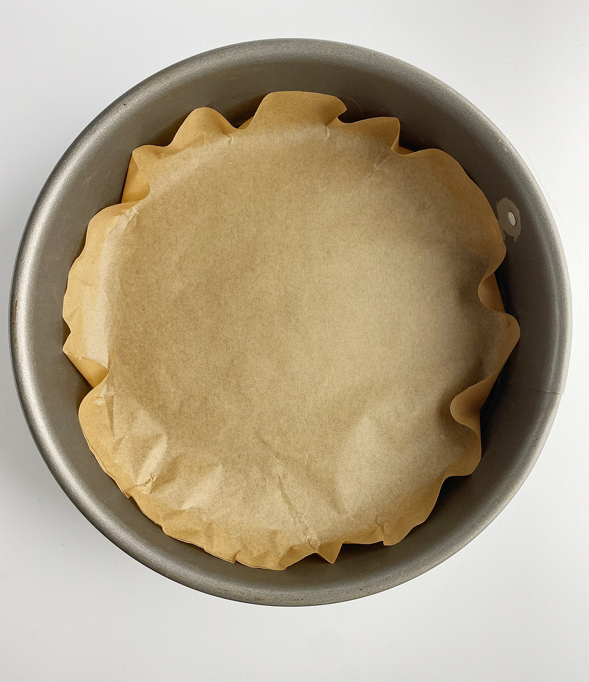 A springform pan lined with parchment paper.