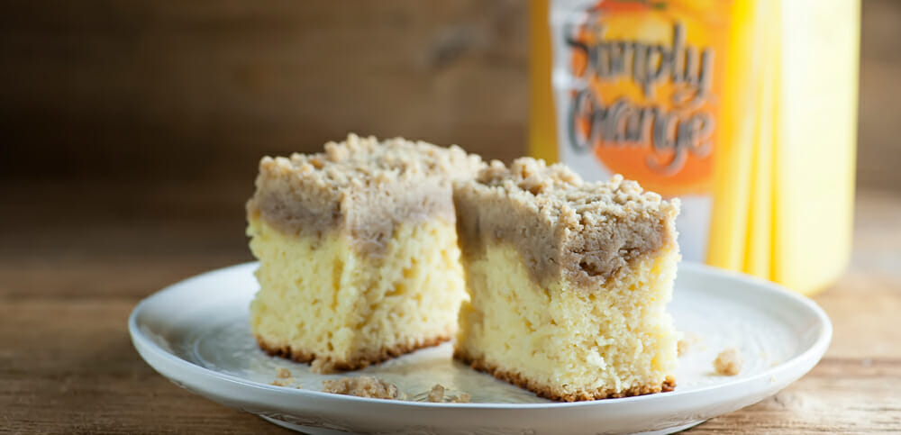 Two pieces of orange juice crumb cake on a plate.
