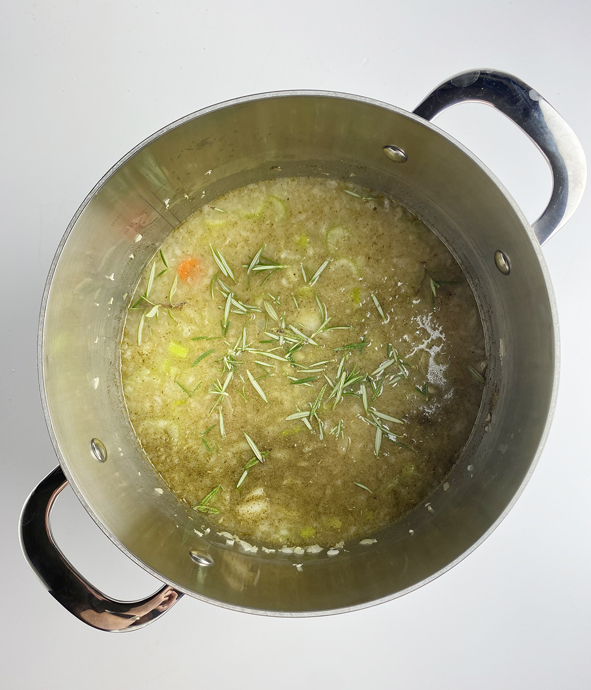 Chicken soup with fresh rosemary sprinkled on top.