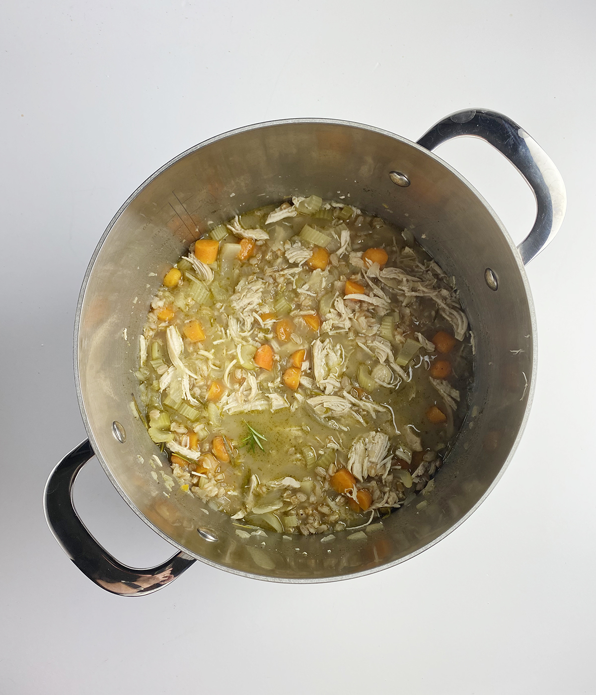 Rosemary chicken soup in a pot.