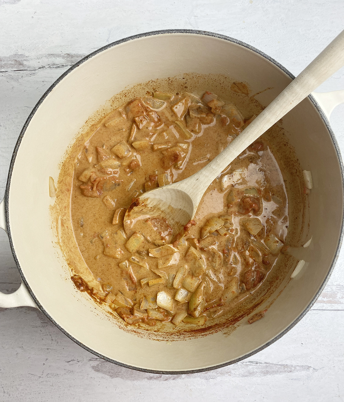 Sauce for coconut beef stew in a pot.