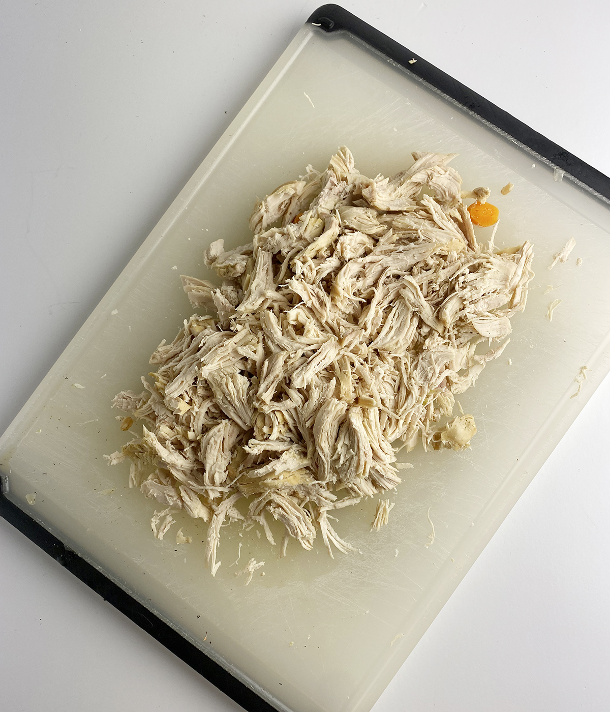 Shredded chicken on a cutting board.