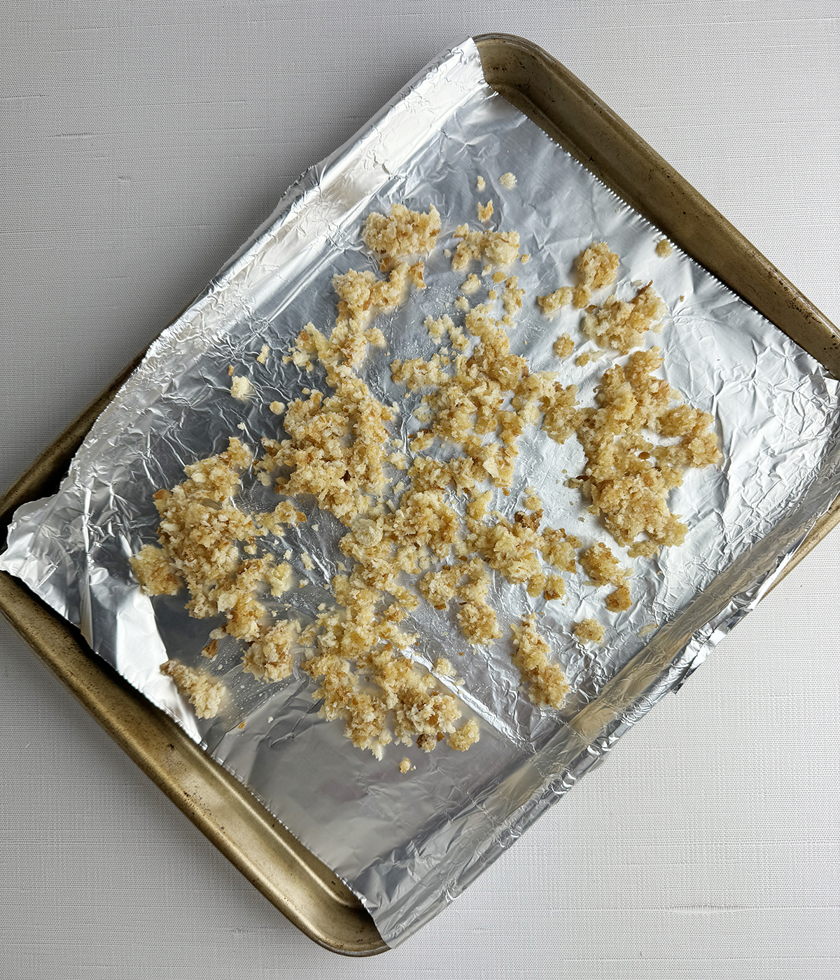 Bread crumbs on a baking sheet ready for the oven.