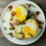 Bacon and egg baked potatoes on a plate.