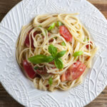 Pasta with brie and tomatoes on a plate.