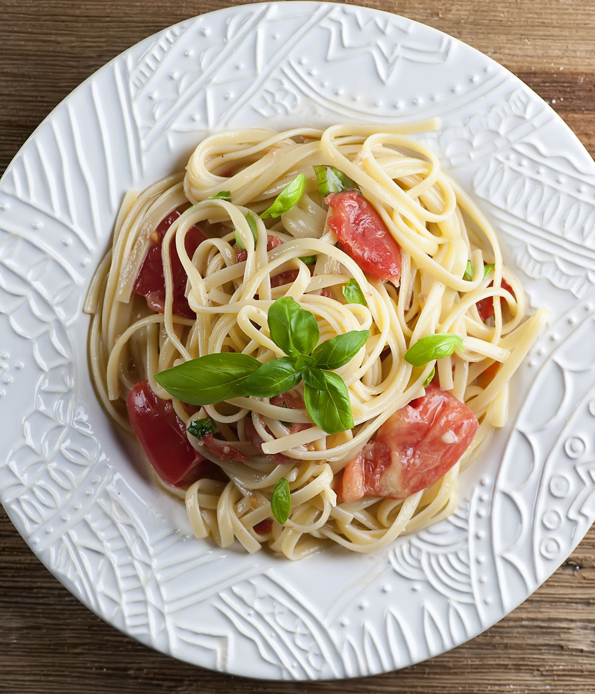 Pasta with brie and tomatoes on a plate.