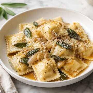 Ravioli with brown butter and sage in a bowl.