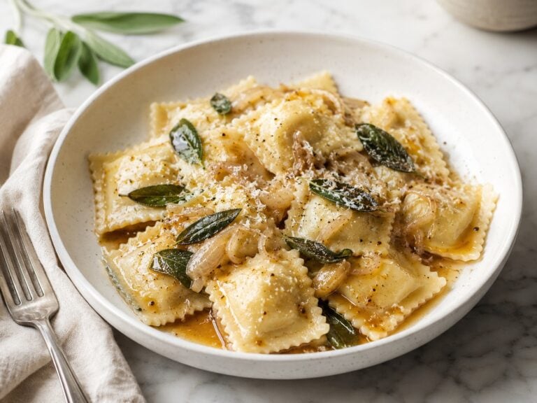 Ravioli with brown butter and sage in a bowl.