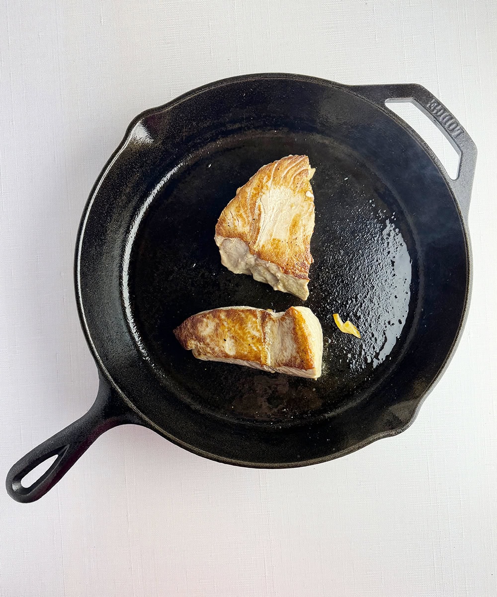Tuna steaks searing in a pan.