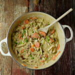 Creamy chicken stew in a dutch oven with a wooden spoon.