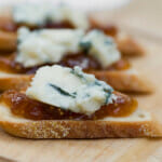 Fig jam and blue cheese crostini in a wooden board.