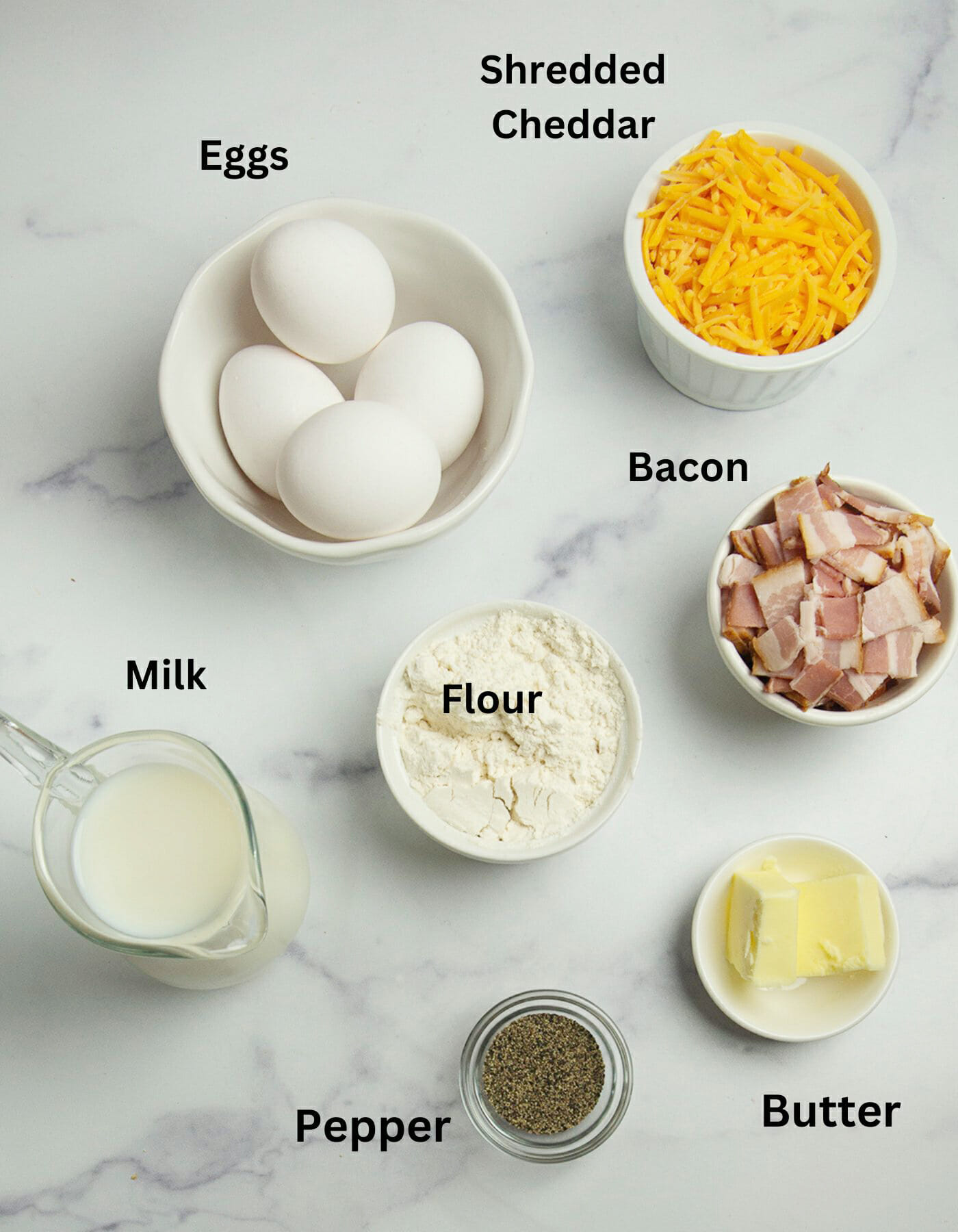 Crustless quiche ingredients on a marble counter.