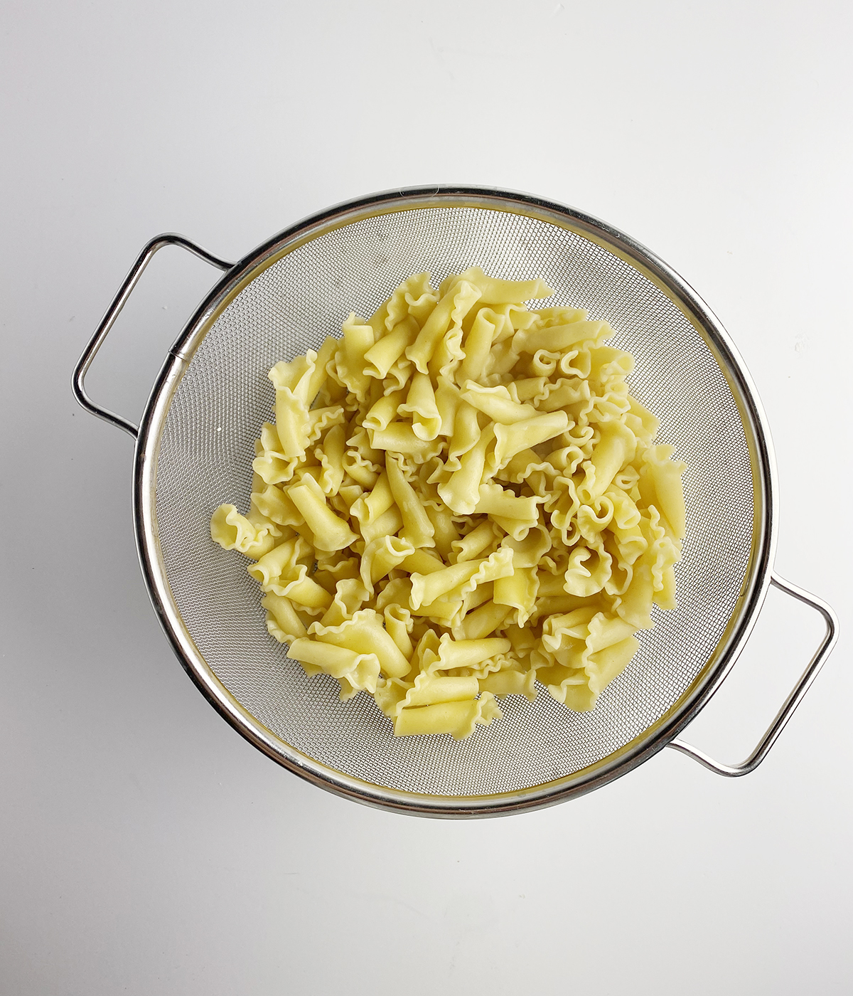 Noodles draining in a strainer.