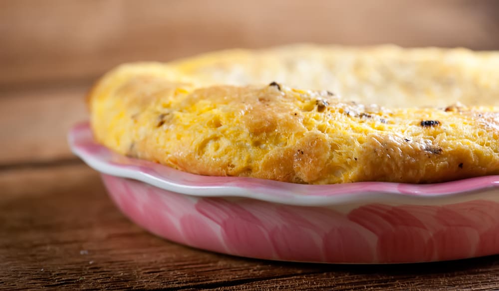 Crustless bacon cheddar quiche in a pie plate.