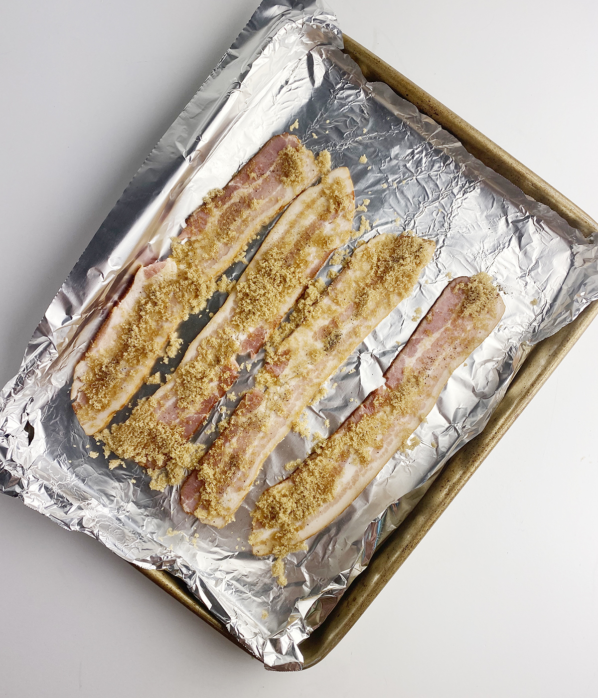Brown sugar coated bacon on a foil lined pan.