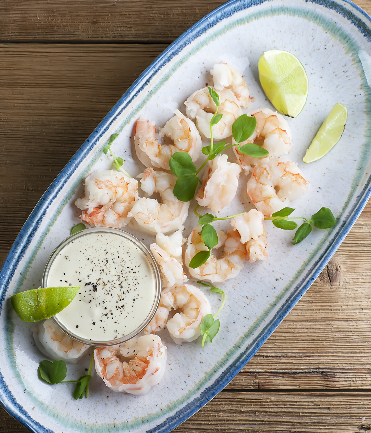 Shrimp with lime dipping sauce on a serving dish.