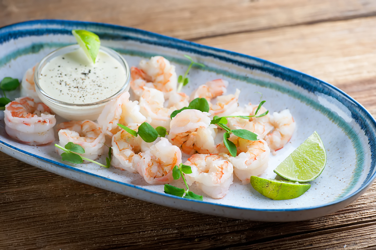 Shrimp with dipping sauce on a platter.