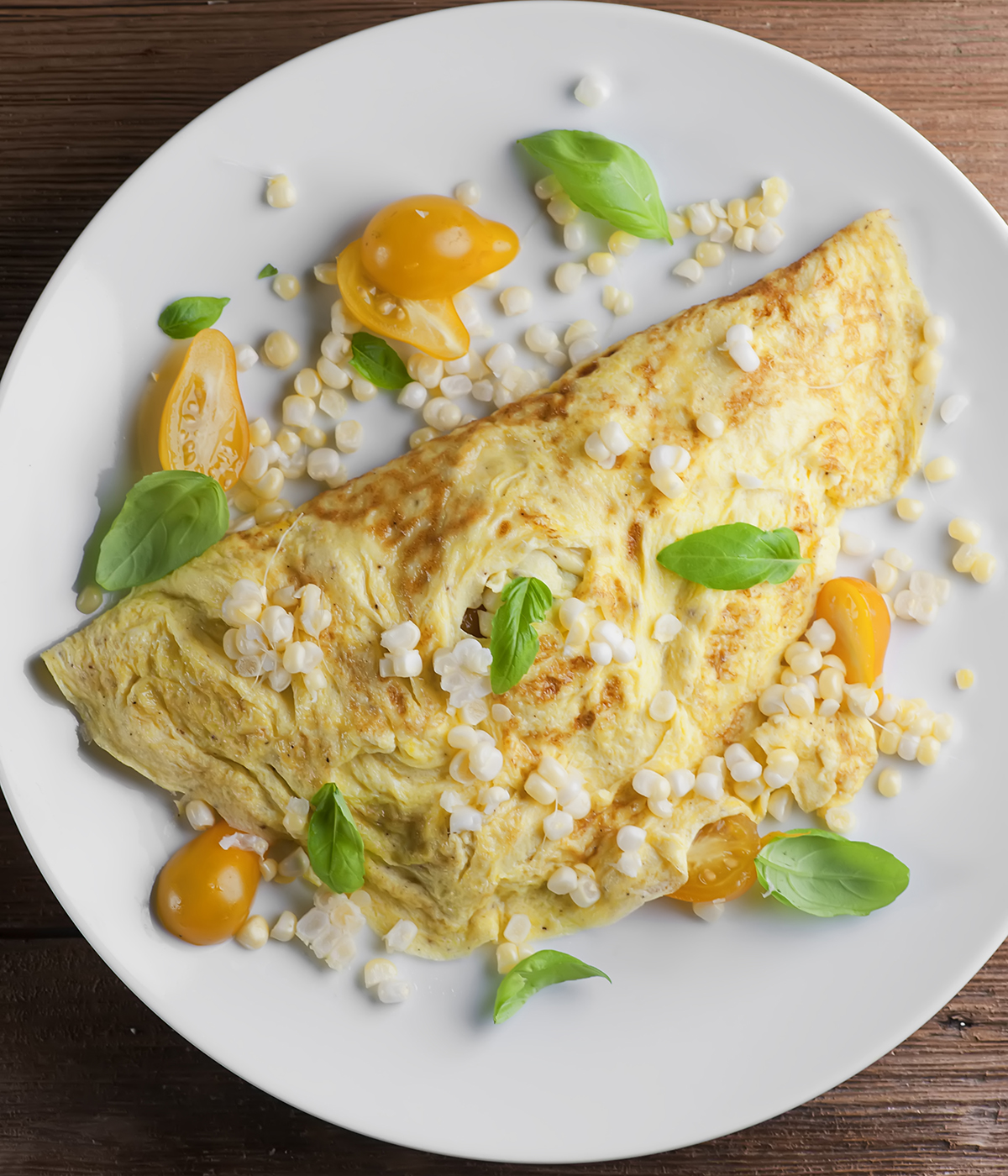 Farmer's omelet on a plate with basil leaves.