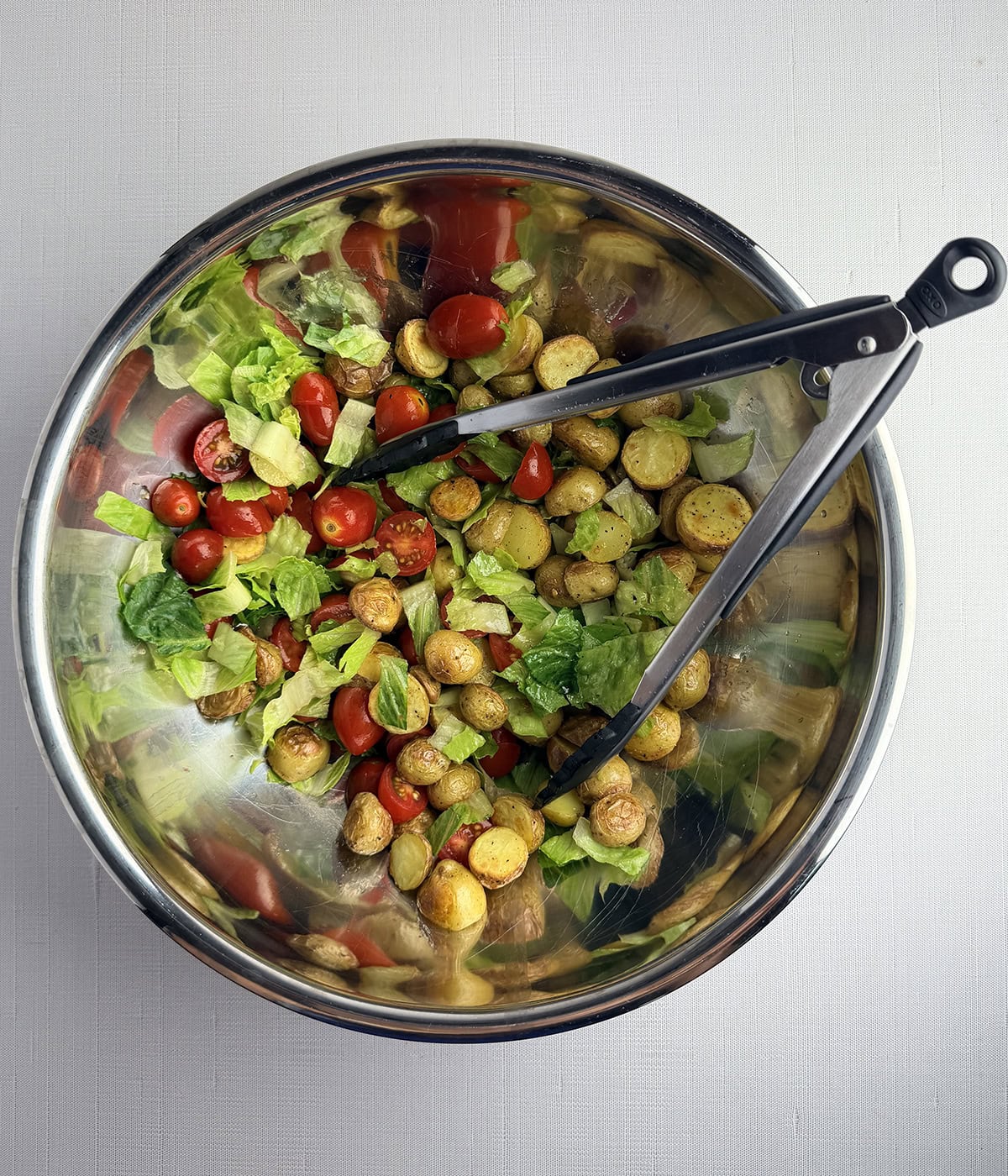 Steak and roasted potato salad in a mixing bowl.