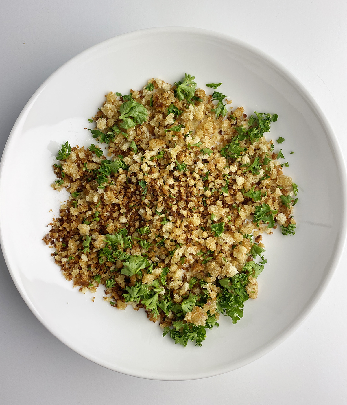 Bowl with breadcrumbs and chopped parsley.