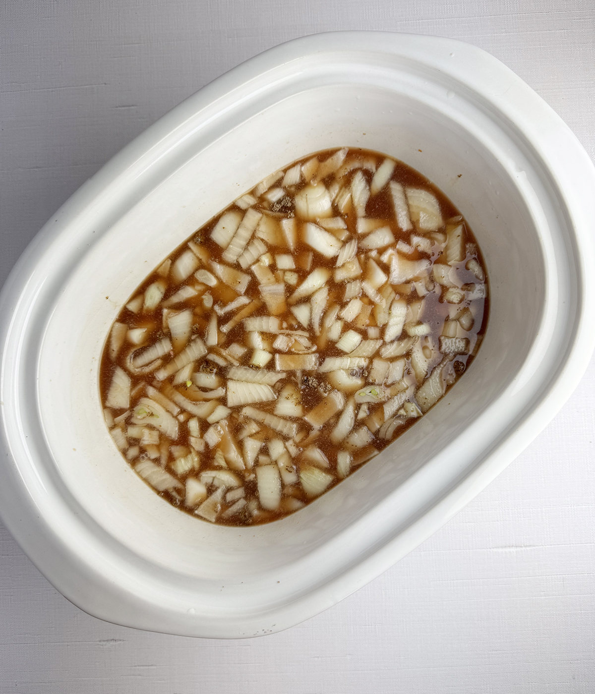 Beef barley soup ingredients in a slow cooker before cooking.