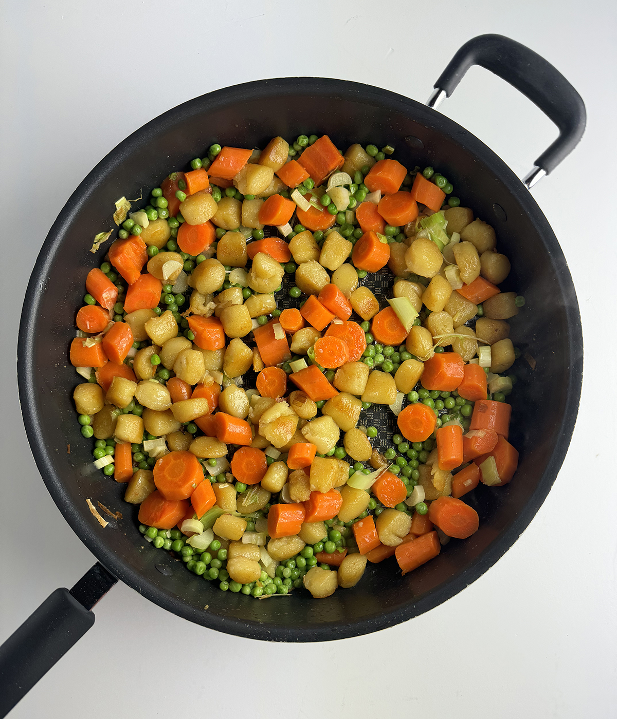 Gnocchi and vegetables in a skillet.