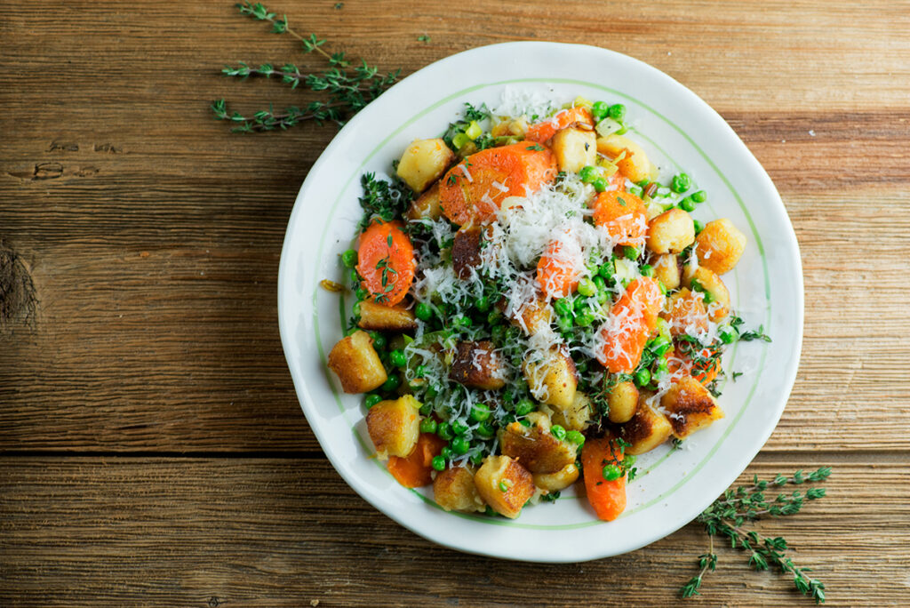 Plate of gnocchi with spring vegetables.