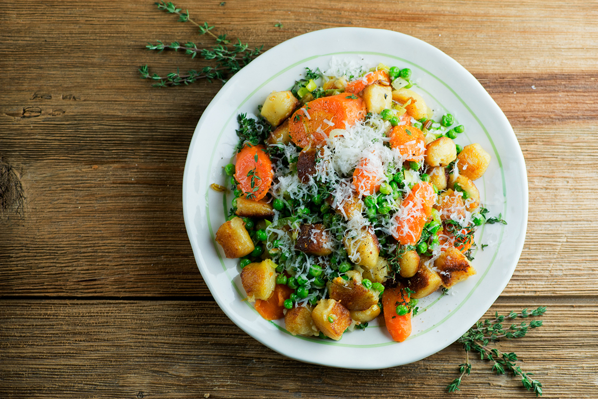 pan-fried gnocchi with spring vegetables Plate of gnocchi with spring vegetables.