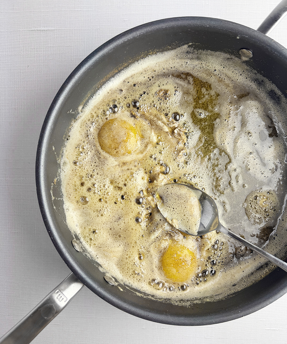 Eggs cooking in brown butter.