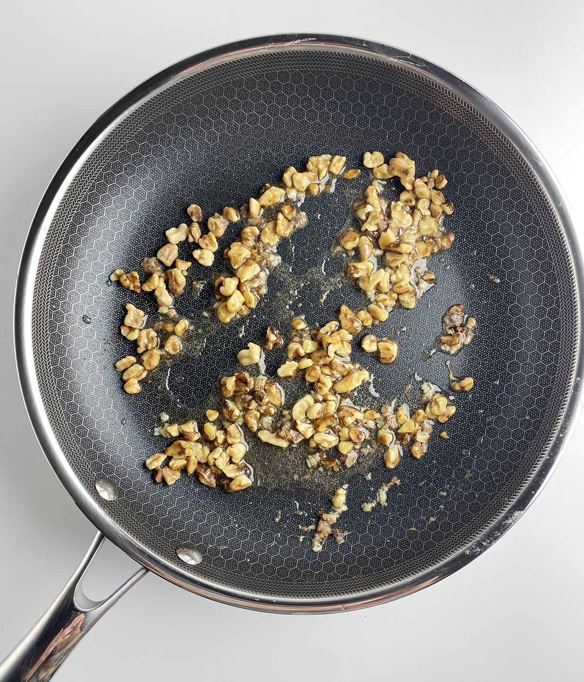 Walnuts and anchovies in a skillet.