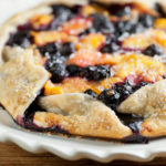 Rustic peach blueberry tart on a plate.