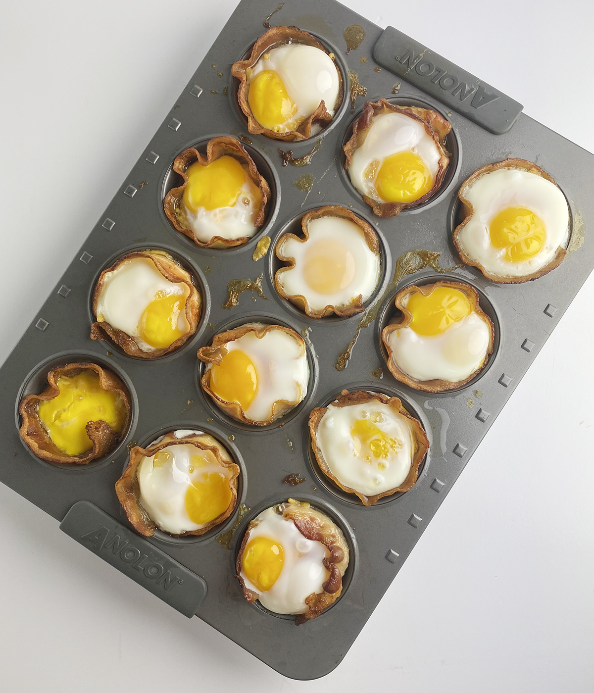 Bacon agg and cheese muffins in a muffin tin.