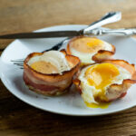 Bacon egg and cheese muffins on a plate.