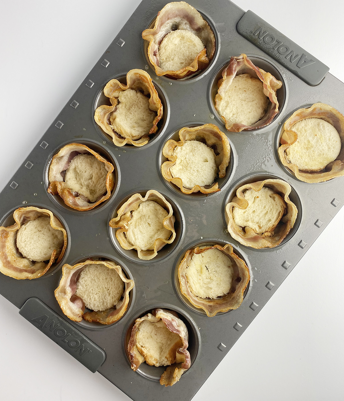 Bacon wrapped around the side of bacon egg and cheese muffins.