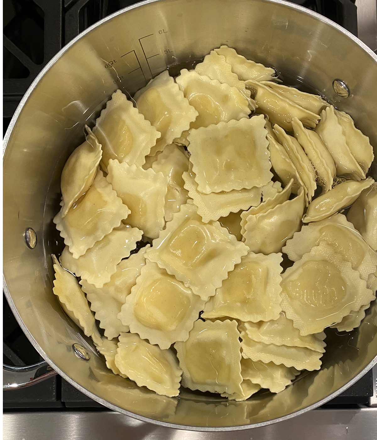 Ravioli cooking in a pot on the stove.